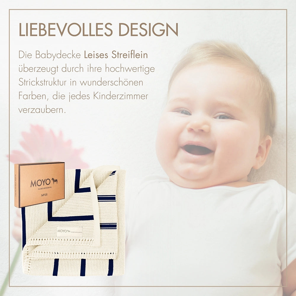 Glückliches Baby mit der weichen MOYO Strickdecke – liebevolles Design für Geborgenheit von Anfang an.