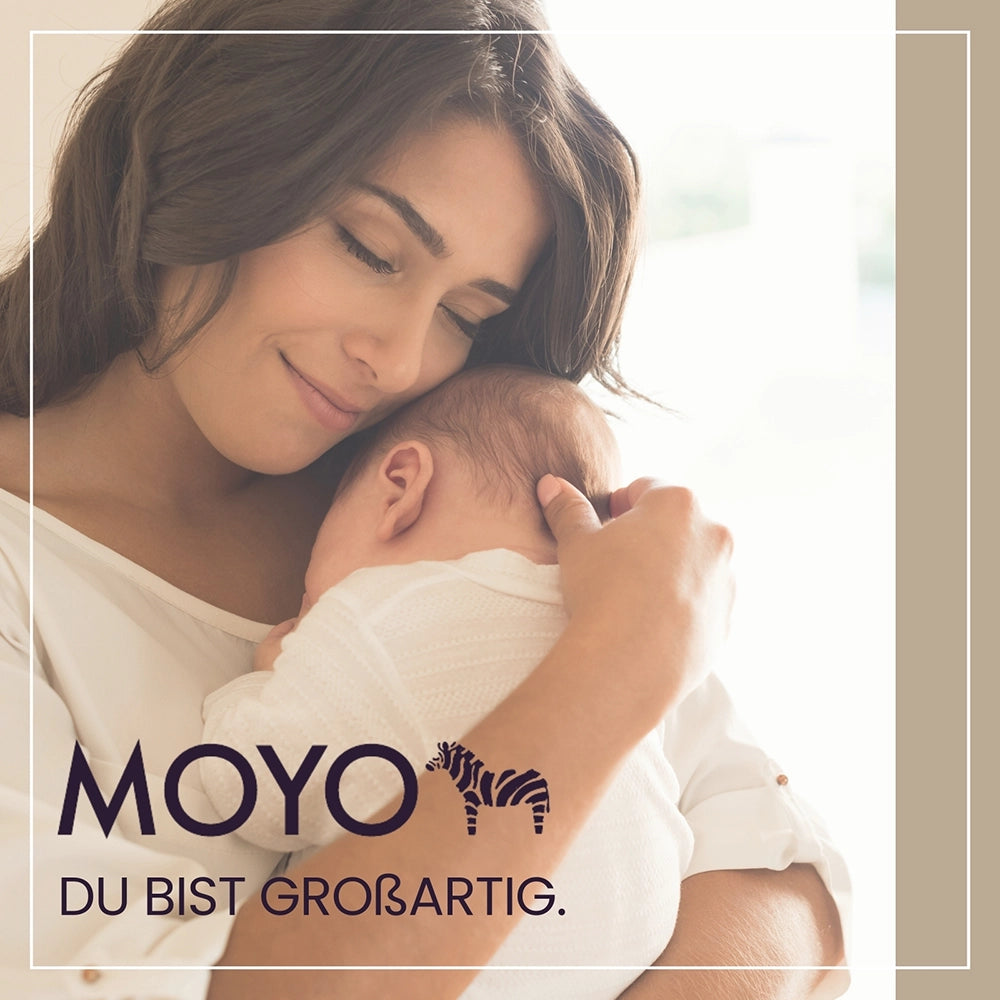 utter hält ihr Neugeborenes in der gestreiften MOYO Bio-Babydecke – nachhaltige Geborgenheit und Qualität.