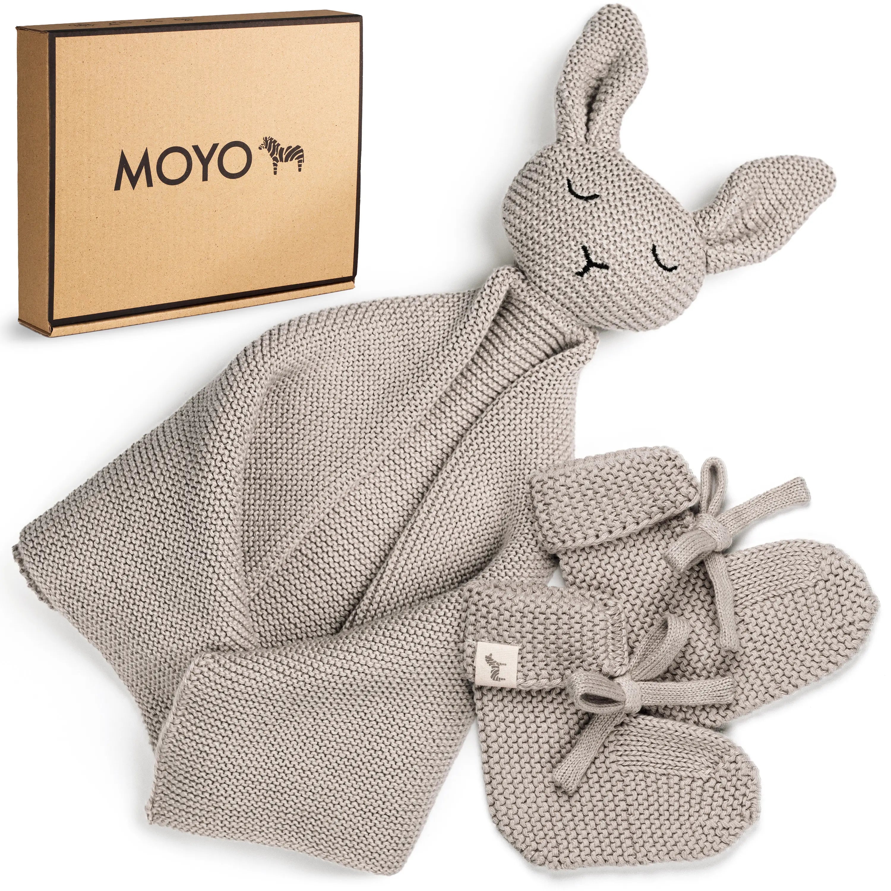 MOYO Baby Geschenkset Hej Baby Grau mit gestricktem Hasen-Schnuffeltuch und Babyschuhen auf weißem Felluntergrund.