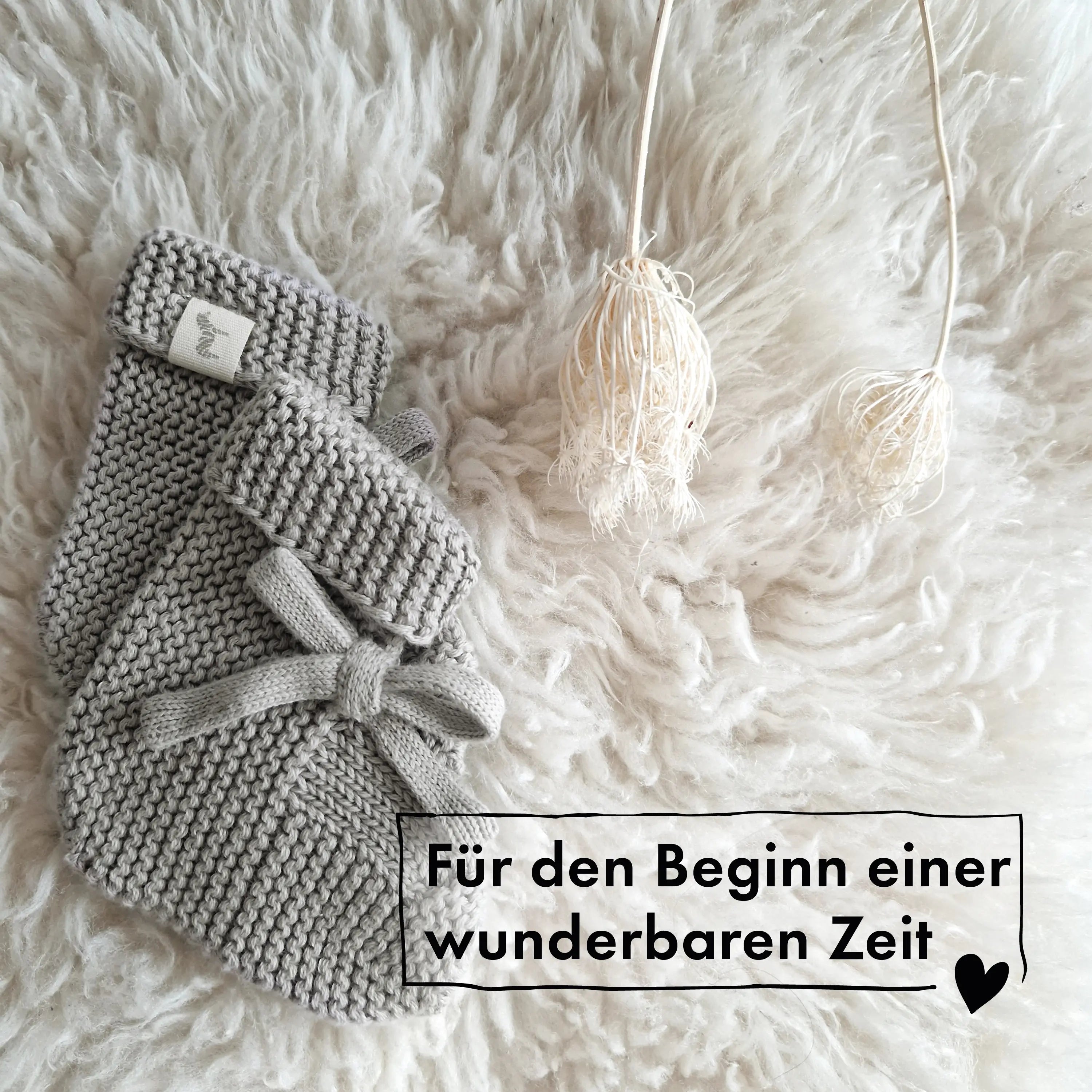 Kuschelweiche graue Baby Strickschühchen mit Schleife für Neugeborene – atmungsaktiv und warm.