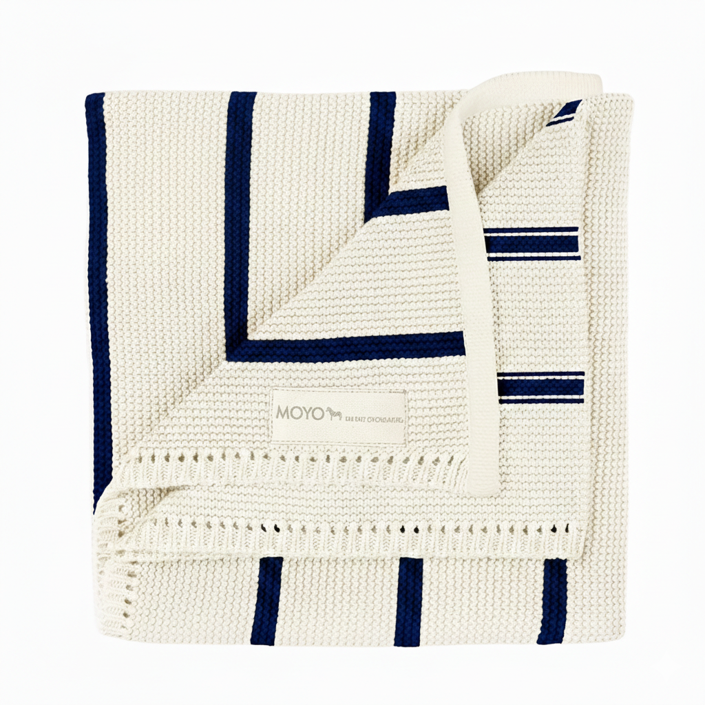 GOTS-zertifizierte Baby-Strickdecke aus Bio-Baumwolle in Cremeweiß mit dunkelblauen Streifen – Modell Leises Streiflein von MOYO.